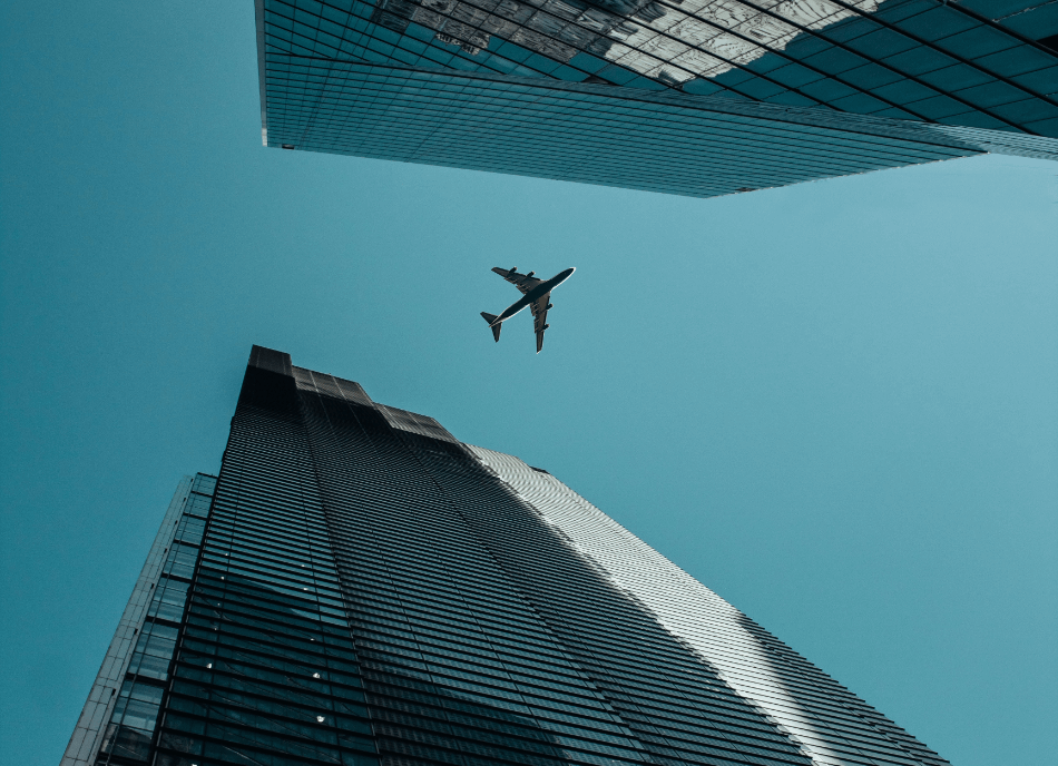 banner de avião sobrevoando cidade, visto de baixo para cima, entre prédios.
